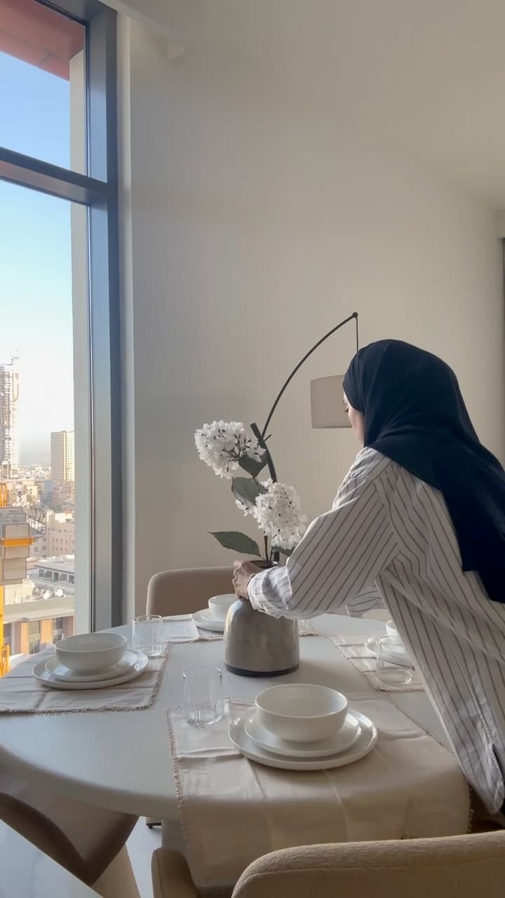 Your designer setting the last flowers on a laid dining table before handover